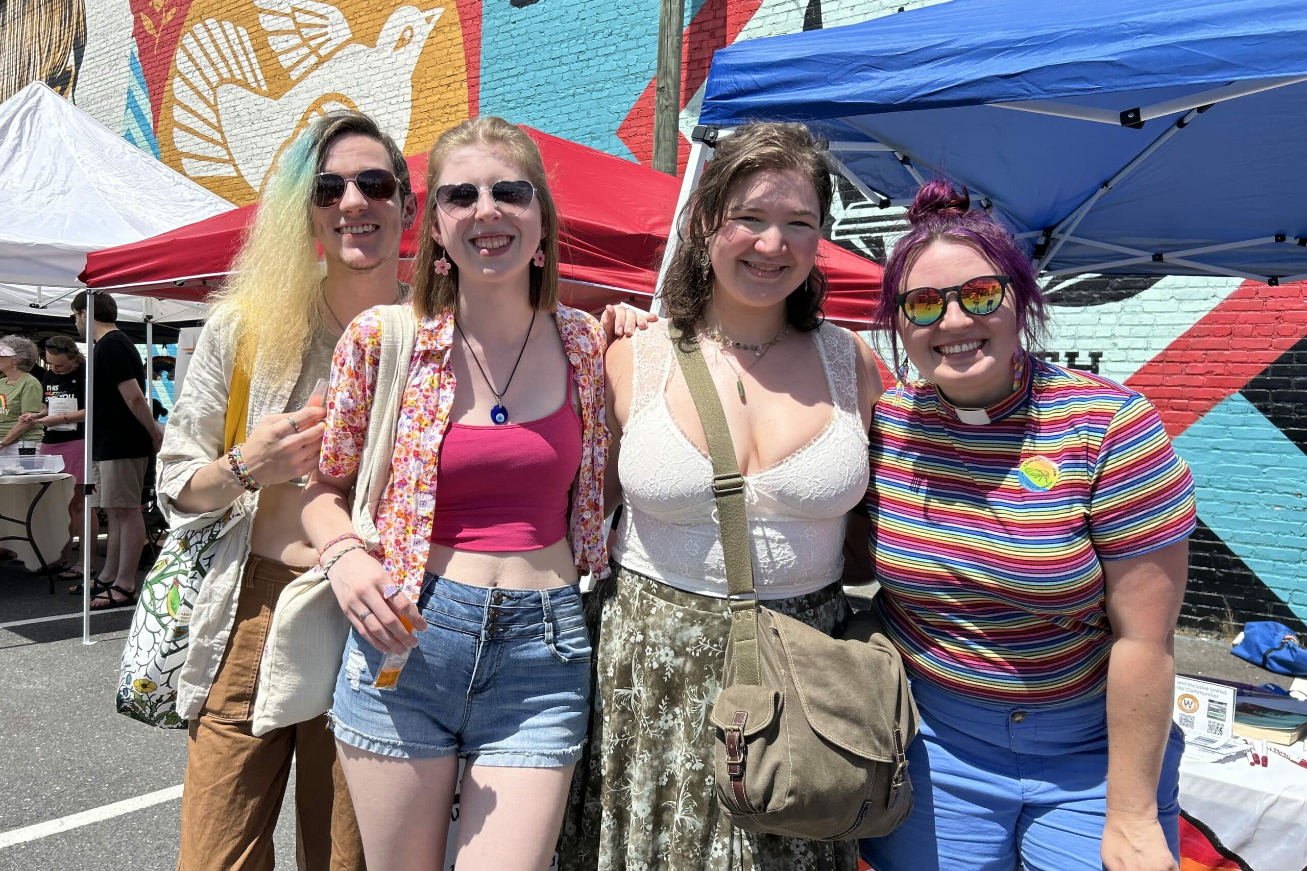 four people in bright clothing smile for the camera